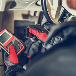 Auto Service Diagnostic Tool in Hands of Vehicle Maintenance Worker. Car Computer Error Reading Using Mobile Device.